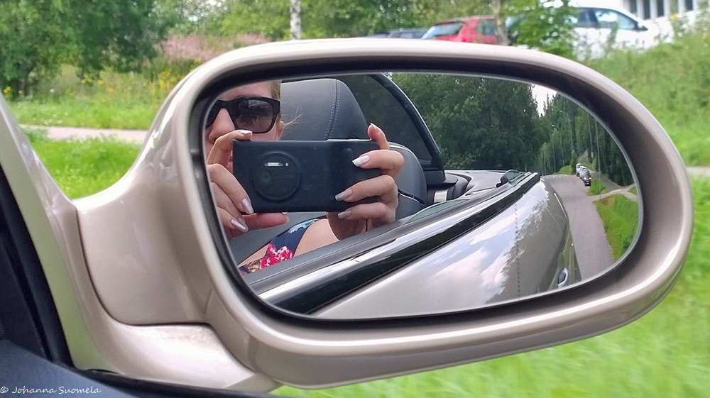 Kuva kuvaajasta auton taustapeilistä