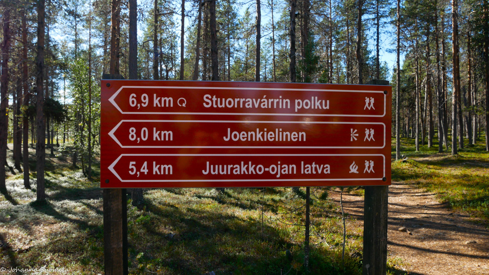 Lemmenjoen kansallispuiston parkkipaikan patikointireittiopaste.