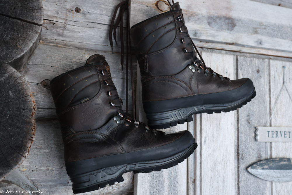 Vaelluskengät uudelleenpohjattuina mökin edustalla roikkumassa.